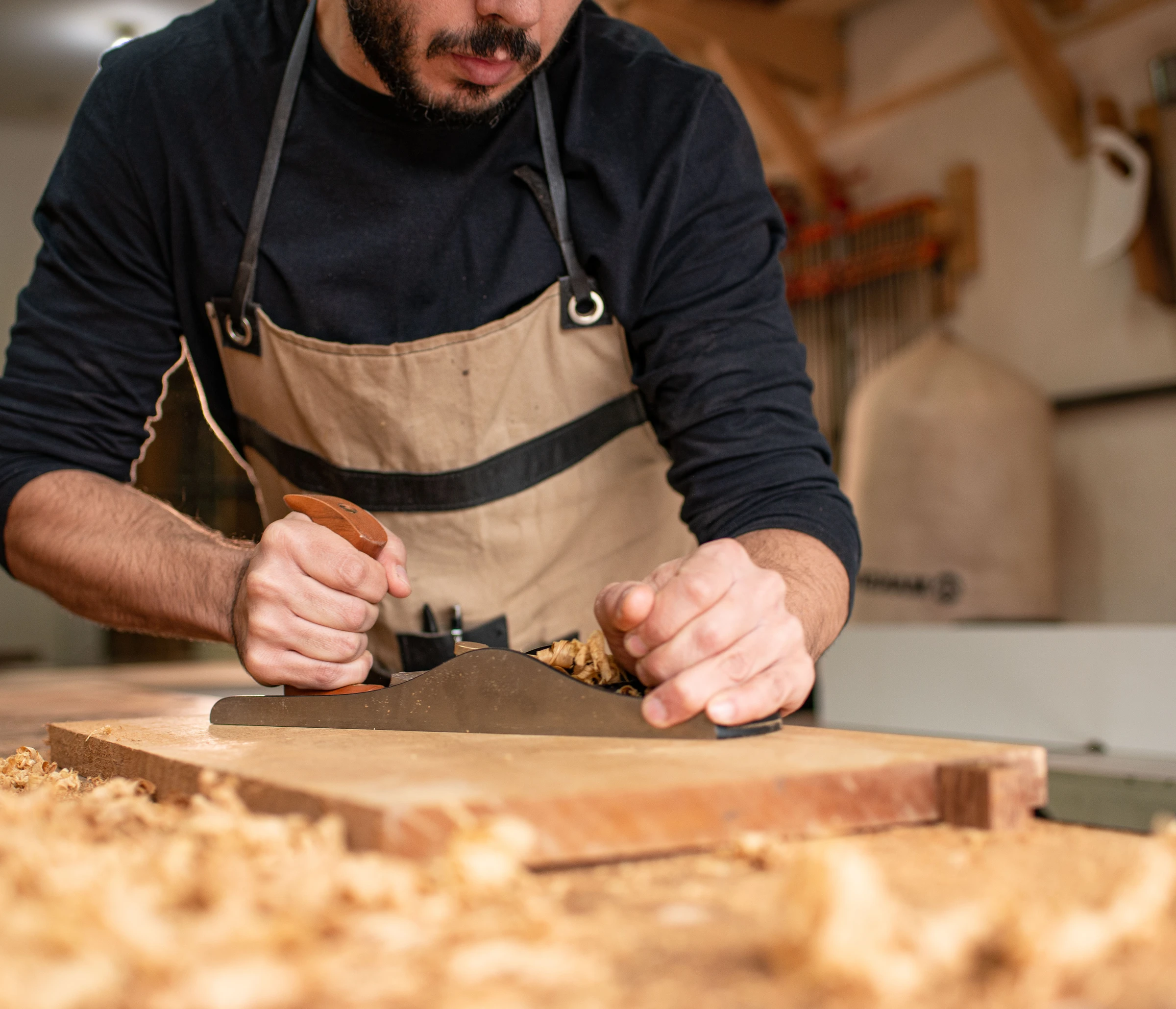 Rafael hand-planing wood at the workbench