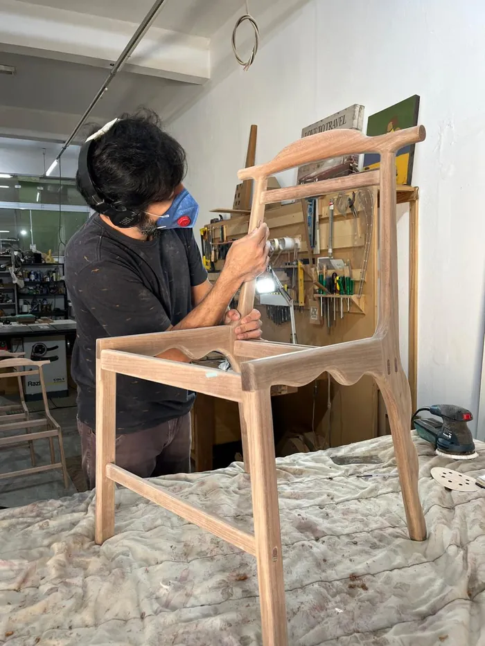 Raw wood structure being sanded by hand in the workshop