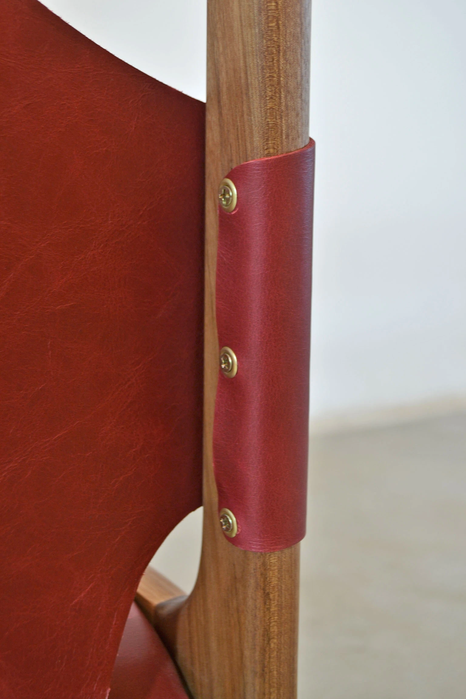 Brass tacks fastening the backrest leather to the leg